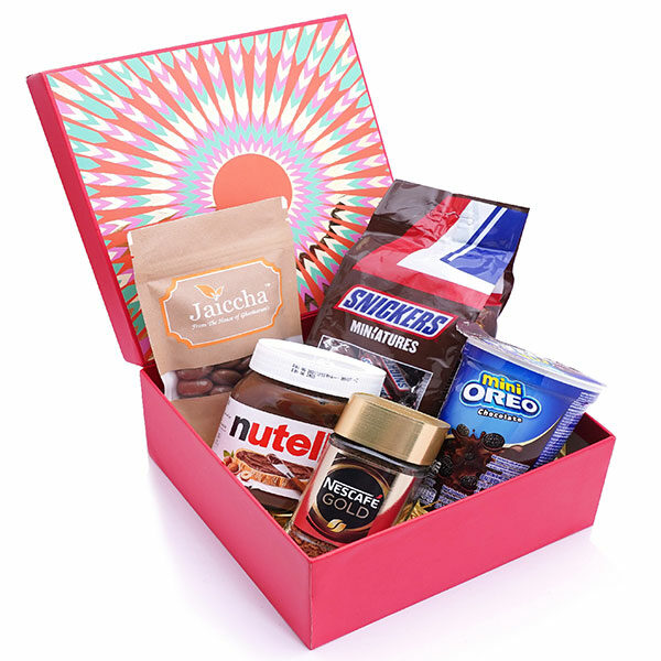 Red hamper box of Snickers, Chocolate Coated Almonds, Nescafe Gold Coffee (50 gms), Nutella and Mini Oreo